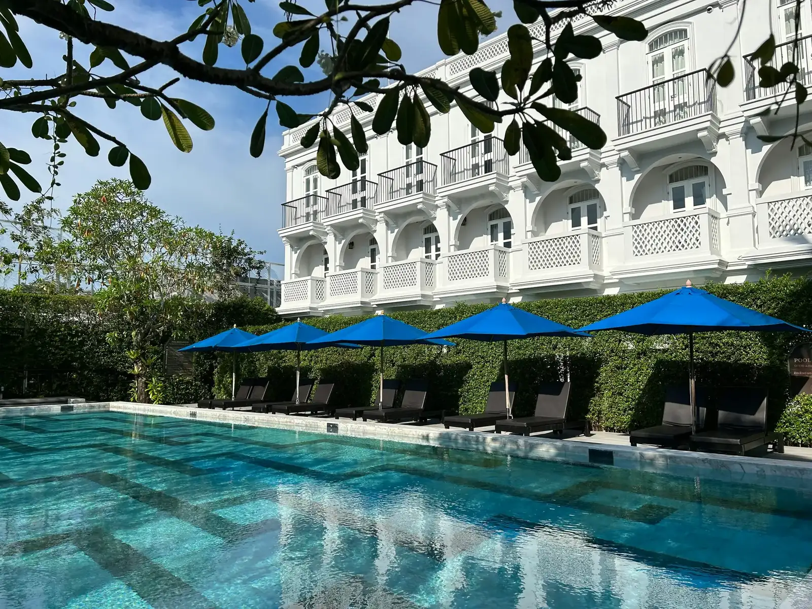 Piscina de hotel com guarda-sóis azuis